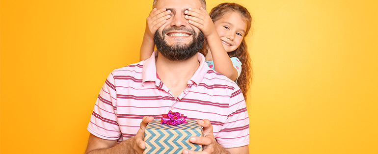 Presente de Dia dos Pais | Pai e filha brancos posam sob fundo na cor laranja | Blog Lojas Solar 